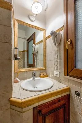 a bathroom with a sink and a mirror at Domus 15 - Guest House in Rome
