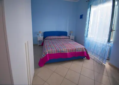 a small bedroom with a bed with a colorful bedspread at ad duas lauros in Rome