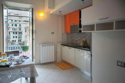 a kitchen with white cabinets and a table and a window at ad duas lauros in Rome