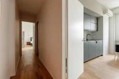 a kitchen with white cabinets and a wooden floor at Pinturicchio's Rooms at Flaminio in Rome