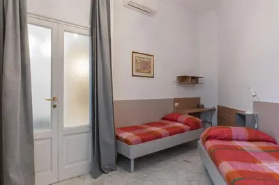 a bedroom with two beds and a mirror at GuestHost - Zia Pina's Apartment in Rome