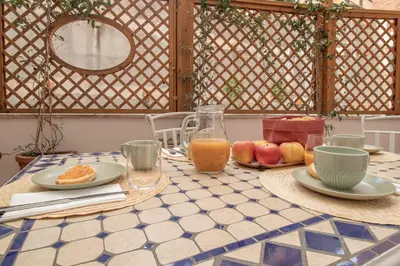 a table with plates of fruit and a pitcher of orange juice at A casa di Carlo Roma Vaticano in Rome