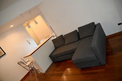 a living room with a black couch and a table at Casa 12 in Rome
