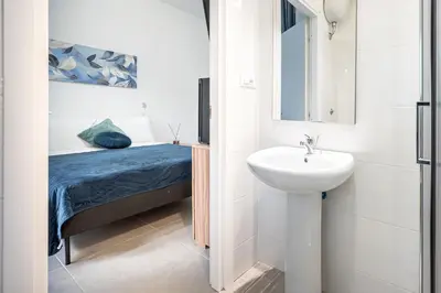 a small bathroom with a sink and a bed at Roman Waves Room - 2 MIN Metro Marconi - 15 MIN Colosseo - A-C & WIFI in Rome
