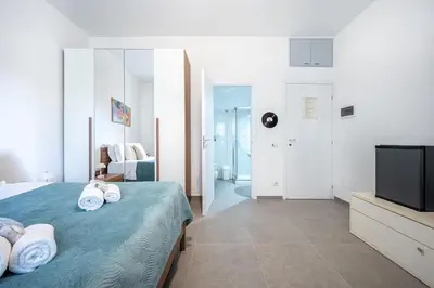 a bedroom with a bed with a television and towels at Roman Waves Room - 2 MIN Metro Marconi - 15 MIN Colosseo - A-C & WIFI in Rome