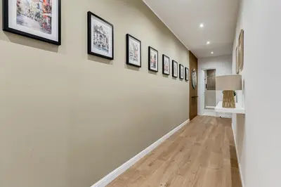 a hallway with a row of framed pictures on the wall at Scipioni Luxury Apartment in Rome