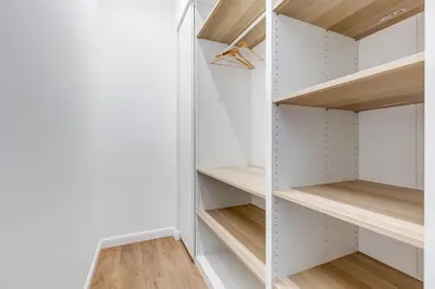 a walk in closet with white walls and wooden shelves at Scipioni Luxury Apartment in Rome