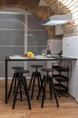 a kitchen with a black table and stools at Troppo Forte appartamento a due passi dal Colosseo in Rome