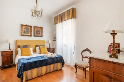 a bedroom with a bed and a chandelier at La Dimora dell'Antiquario in Rome