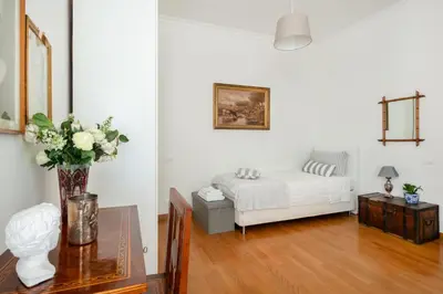 a bedroom with a bed and a table with a vase of flowers at La Dimora dell'Antiquario in Rome