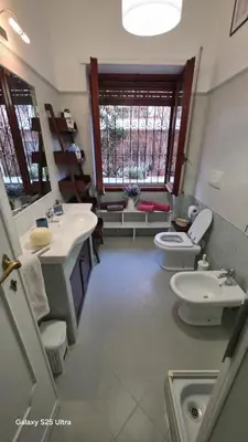 a bathroom with two sinks and a toilet and a window at Casa Orietta in Rome