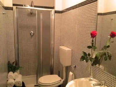 a bathroom with a shower with a toilet and a sink at B&B Trastevere in Bed in Rome