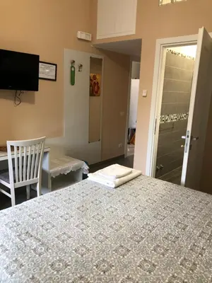 a bedroom with a bed and a chair and a television at B&B Trastevere in Bed in Rome