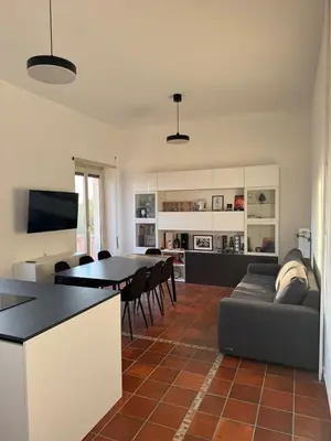 a kitchen and living room with a table and a couch at The Monteverde Penthouse in Rome