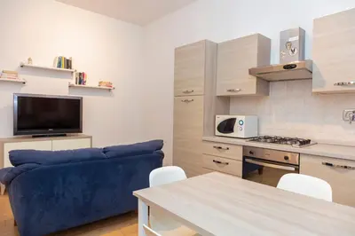a living room with a blue couch and a kitchen at Appartamento Rea Silvia in Rome
