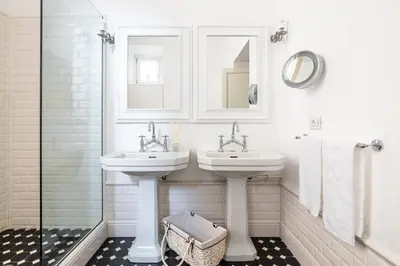 a white bathroom with two sinks and a shower at Casa Giulia, a Burghesius home in Rome