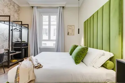 a bedroom with a large white bed with green accents at Dionigi 43 Private Suites by Premium Suites Collection in Rome