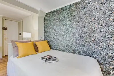 a bedroom with a large white bed with yellow pillows at La Casina your suite in Monti in Rome
