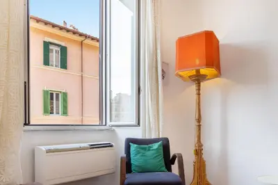 a lamp and a chair in a room with a window at Casa Assunta in Rome