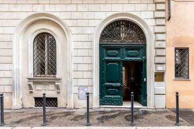 a green door on a building with two windows at Vittoria Charme in Rome