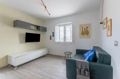 a living room with a couch and a tv at San Paolo - 10 min from Metro and 30 mq Terrace in Rome