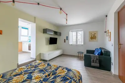 a bedroom with a bed and a couch and a tv at San Paolo - 10 min from Metro and 30 mq Terrace in Rome
