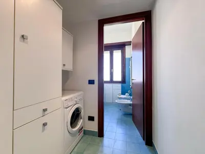 a bathroom with a washer and dryer in a room at Escher's Penthouse on Nomentana in Rome