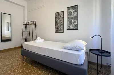 a bed in a room with two pictures on the wall at Escher's Penthouse on Nomentana in Rome