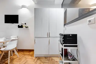 a kitchen with a refrigerator and a table at Trastevere One by GHOR in Rome