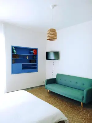 a living room with a green couch and a bed at DOMUS REMO Room #1 in Rome