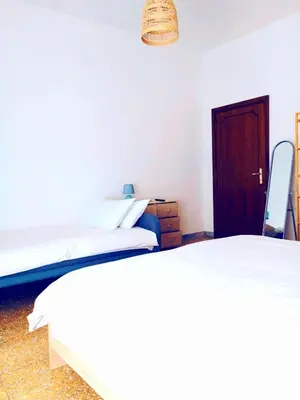 a bedroom with two beds and a wooden door at DOMUS REMO Room #1 in Rome