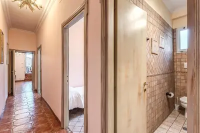 a hallway with a bathroom with a toilet and a bed at Casa Vacanze San Giovanni in Rome