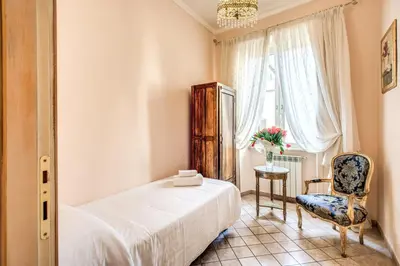 a bedroom with a bed and a chair and a window at Casa Vacanze San Giovanni in Rome