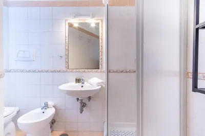 a white bathroom with a sink and a mirror at Elegantis La Dolce Vista Apartment with private terrace and fantastic View in Rome
