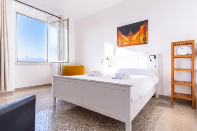 a white bedroom with a white bed and a window at Elegantis La Dolce Vista Apartment with private terrace and fantastic View in Rome