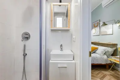 a bathroom with a sink and a shower and a bed at BDC - Love nest! Small but cozy in Rome