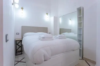 a white bedroom with a large bed with white sheets at Oliviero - Piazza Navona Suite in Rome