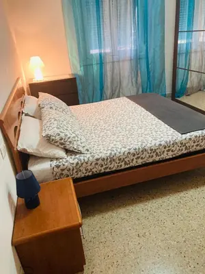 a bedroom with a bed with blue curtains and a table at Cozy Comfy House in Rome Center in Rome
