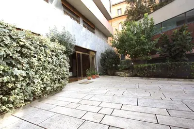 a courtyard in front of a building with plants at Villa Borghese Holiday House in Rome