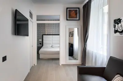 a living room with a bed and a mirror at LHP Suite Roma Piazza del Popolo in Rome