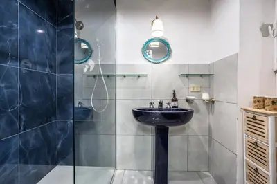 a bathroom with a sink and a shower at La Piccola Retró , urban color and comfort in Rome