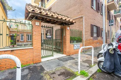 a motorcycle parked in front of a building with a gate at La Piccola Retró , urban color and comfort in Rome
