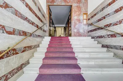 a staircase with purple and white carpeting and a brick wall at BDC - Central charming 2-Bdr! in Rome