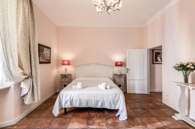 a bedroom with a white bed and a chandelier at Casa Vacanze Collina in Rome
