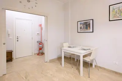 a white dining room with a white table and chairs at Dreaming in Trastevere in Rome