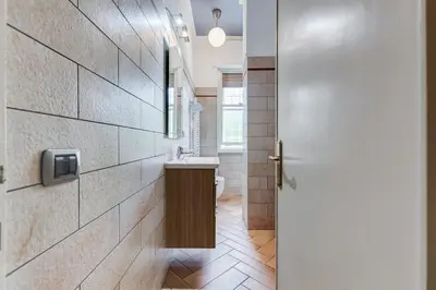 a bathroom with a sink and a toilet and a door at Ferravilla Apt, 2 min to subway! in Rome
