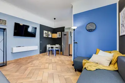 a living room with a couch and a blue wall at Ferravilla Apt, 2 min to subway! in Rome