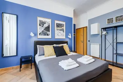 a blue bedroom with a bed with towels on it at Ferravilla Apt, 2 min to subway! in Rome