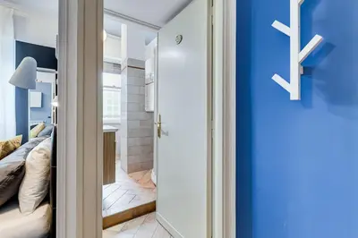 a bedroom with a bed and a blue wall at Ferravilla Apt, 2 min to subway! in Rome