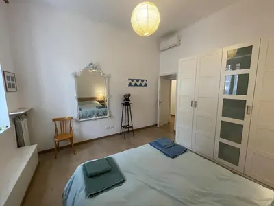 a bedroom with a bed and a mirror and a chair at Theo's House in Rome Ostiense in Rome